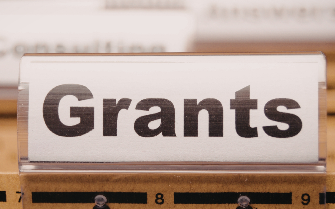Filing cabinet tab labelled "Grants" among folders in a document drawer